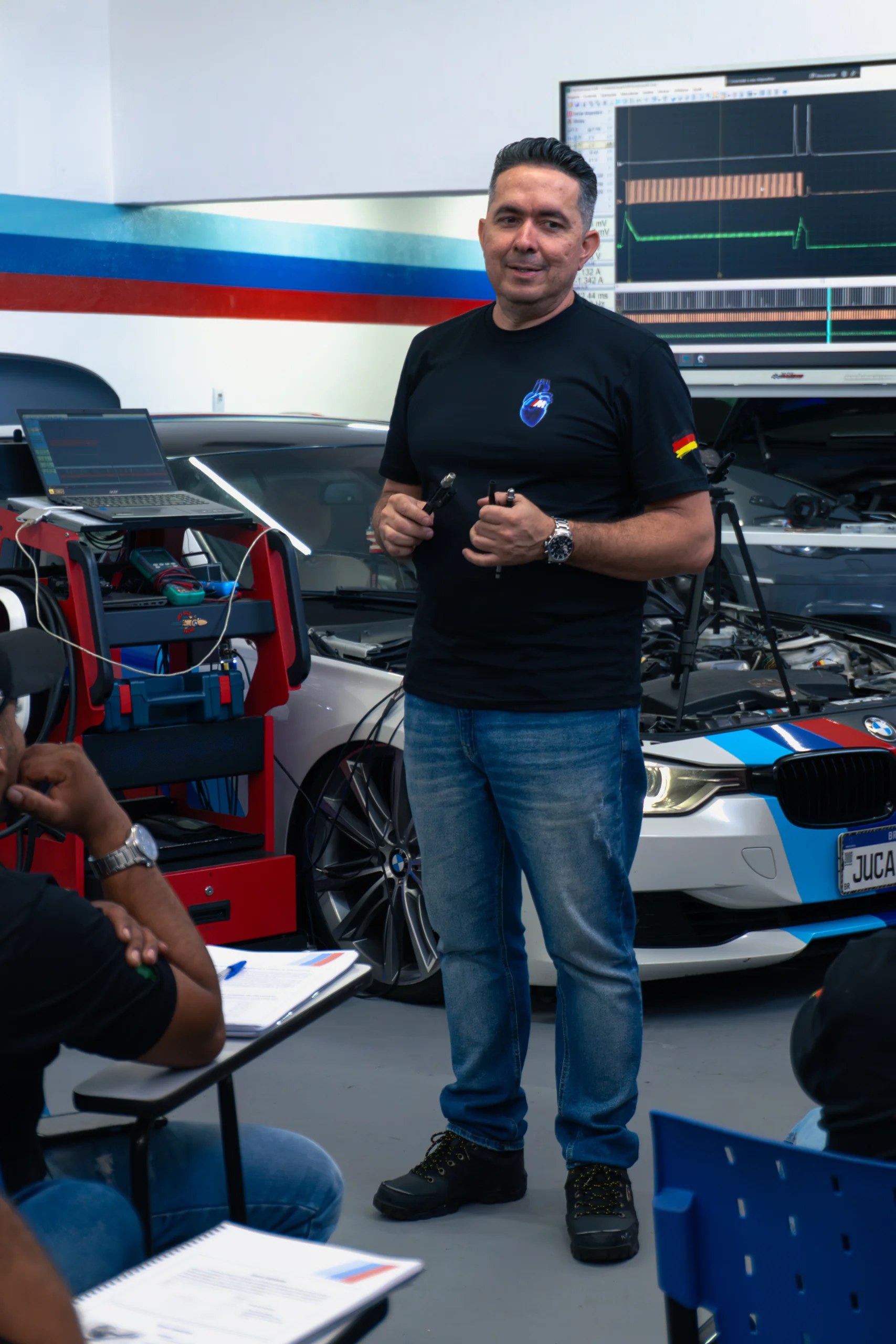 Bruno Juca Bala dando aula ao lado de uma BMW