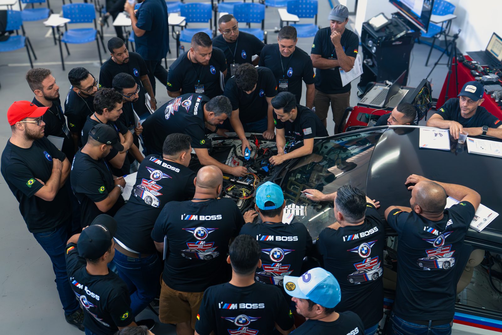 Turma em volta do motor de uma BMW
